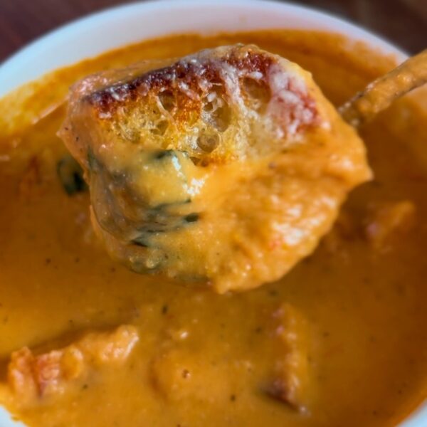 Roasted tomato soup topped with grilled cheese croutons