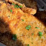 Golden breaded chicken cutlets sprinkled with fresh chopped parsley