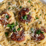 Browned chicken meatballs over creamy orzo with parmesan and chopped parsley