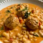 Meatballs, small shells and spinach in a creamy tomato soup