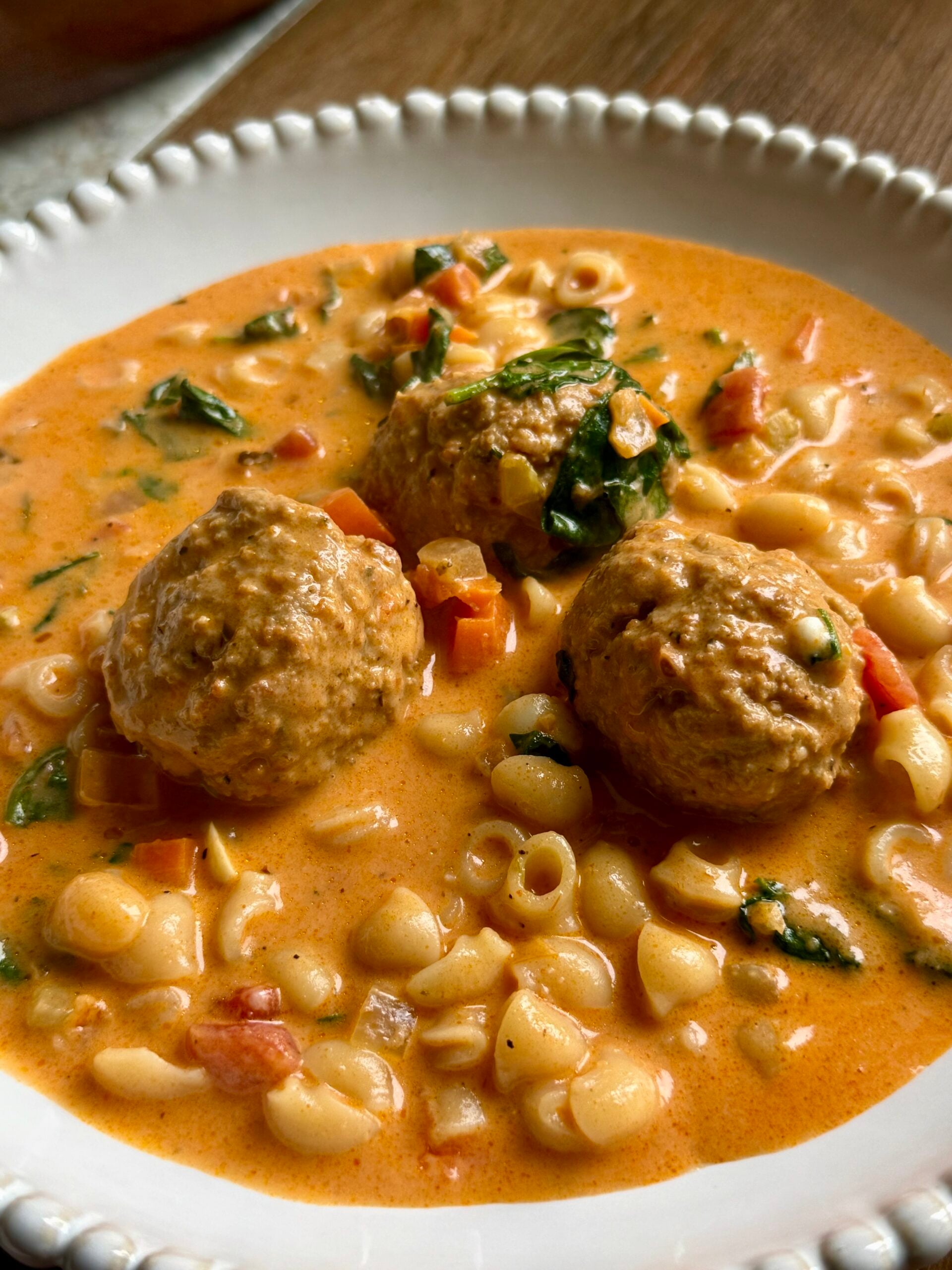 Meatballs, small shells and spinach in a creamy tomato soup