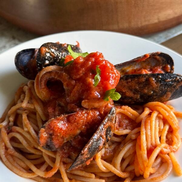 Spaghetti topped with mussels and calamari in a bright tomato seafood sauce