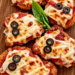 Chicken parmesan cutlets decorated as mummies with mozzarella strips and olive eyes