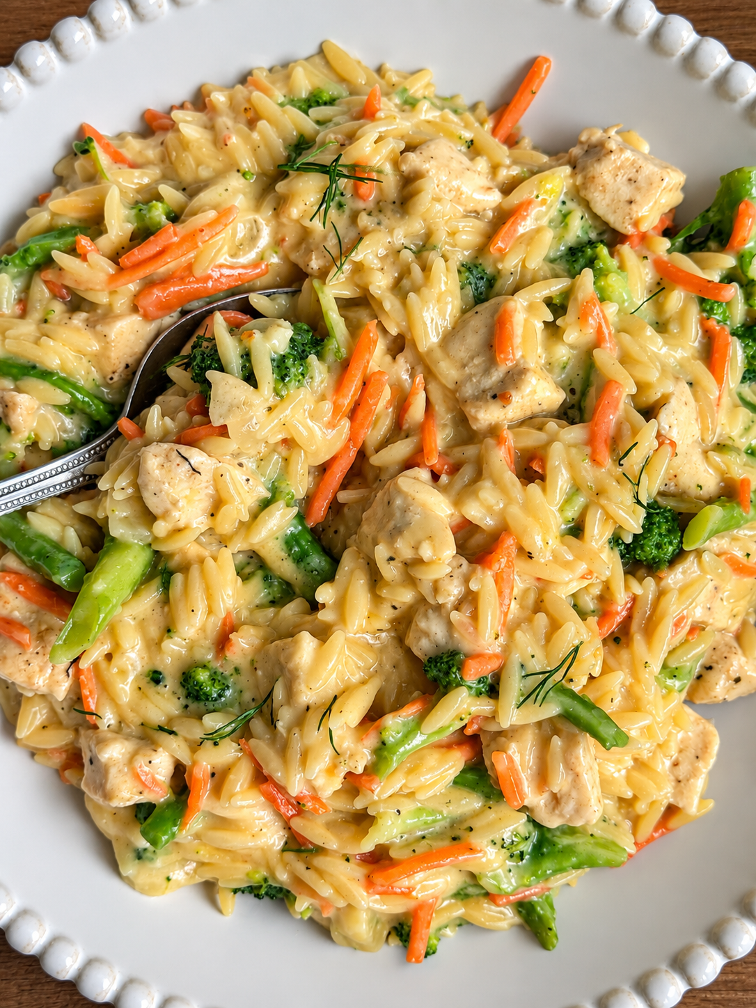 Orzo with chicken, broccoli and shredded carrot in a creamy cheddar sauce