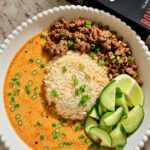 Coconut broth bowl with ground beef, jasmine rice, cucumber and lime wedges
