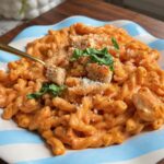 Chicken pasta alla vodka with corkscrew pasta, parmesan and basil on a blue-striped plate